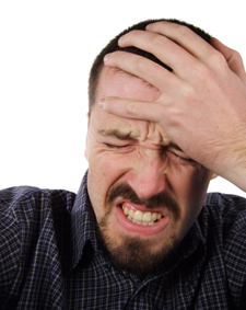 Man clenching teeth with headache